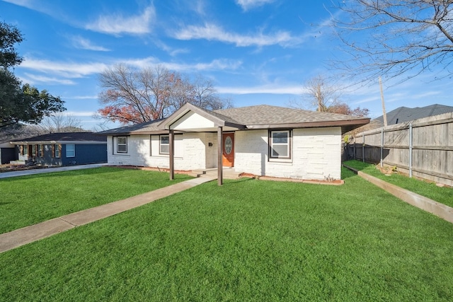 single story home with a front lawn, a shingled roof, fence, and brick siding