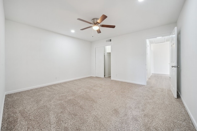 unfurnished bedroom featuring ceiling fan, a walk in closet, light carpet, and a closet