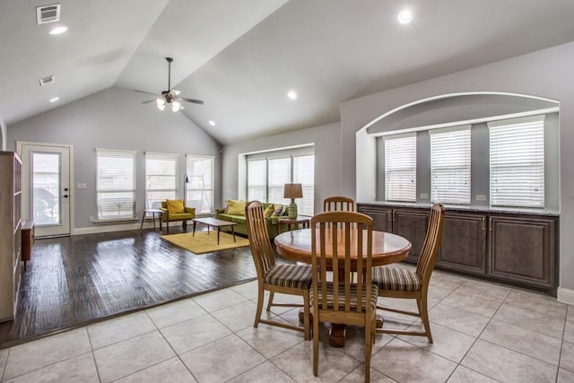 tiled dining area featuring high vaulted ceiling and ceiling fan