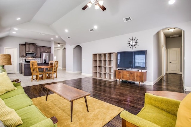 living room with ceiling fan, vaulted ceiling, and hardwood / wood-style floors