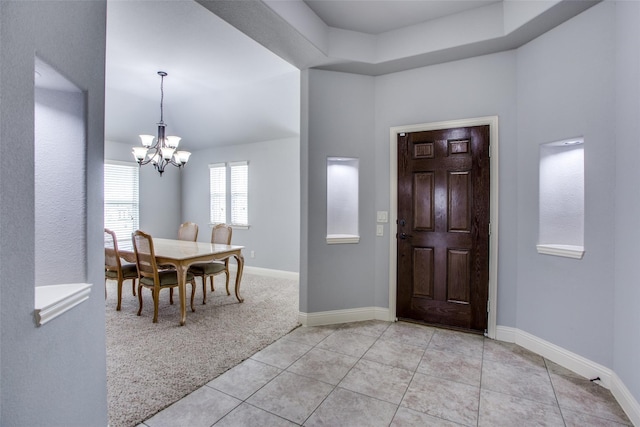 tiled entrance foyer with an inviting chandelier