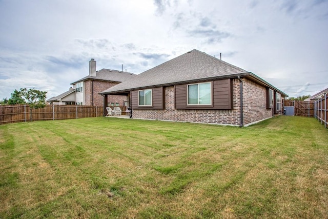 rear view of property featuring central AC, a lawn, and a patio