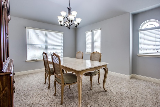 dining room with light colored carpet, plenty of natural light, and a chandelier