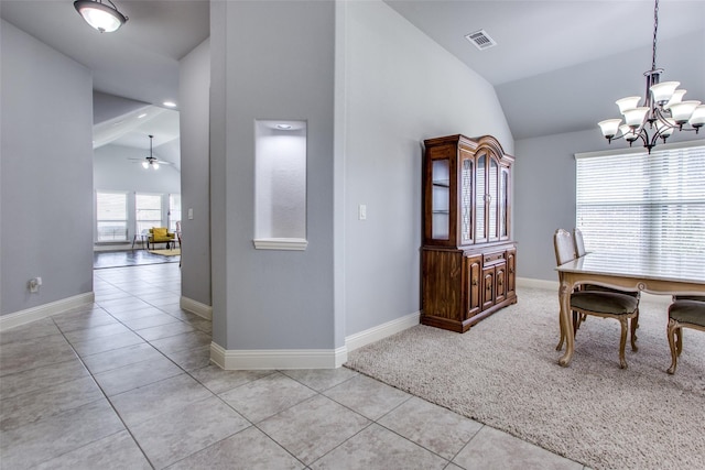 tiled dining space featuring lofted ceiling and ceiling fan with notable chandelier