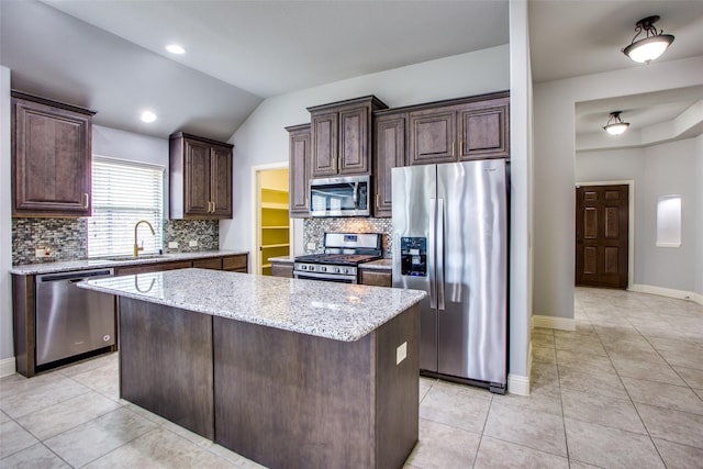 kitchen with dark brown cabinets, appliances with stainless steel finishes, sink, and a kitchen island