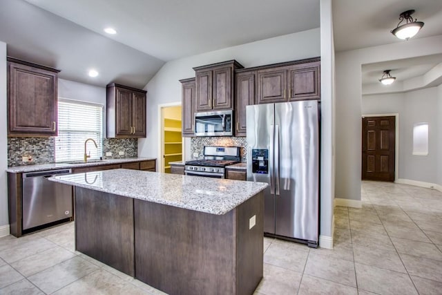 kitchen with sink, dark brown cabinets, a center island, and appliances with stainless steel finishes