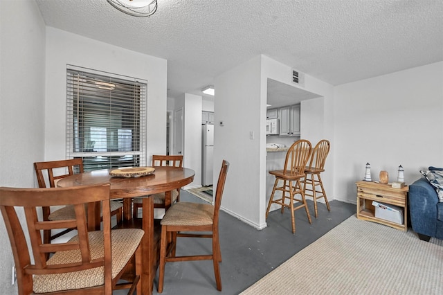 dining space with concrete floors and a textured ceiling