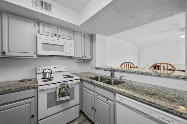 kitchen with sink, white appliances, gray cabinets, and a textured ceiling