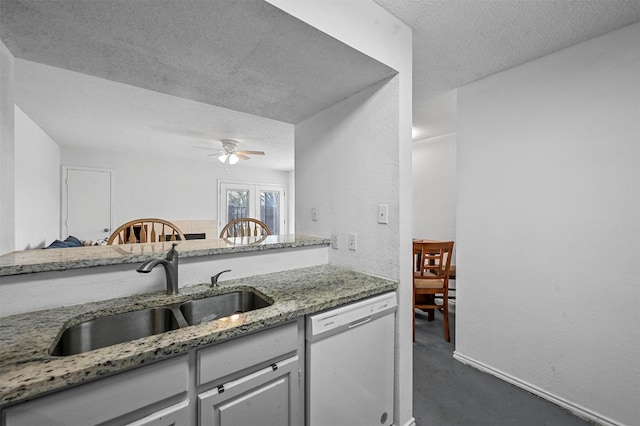 kitchen with sink, stone countertops, a textured ceiling, white dishwasher, and ceiling fan