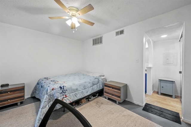 bedroom with ceiling fan and a textured ceiling