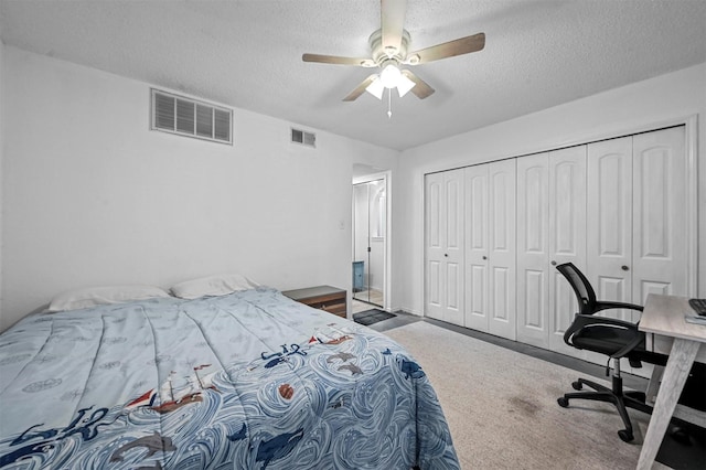 bedroom featuring a closet, ceiling fan, carpet floors, and a textured ceiling