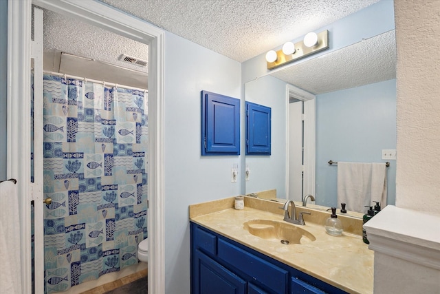 full bathroom featuring visible vents, a shower with curtain, toilet, a textured ceiling, and vanity