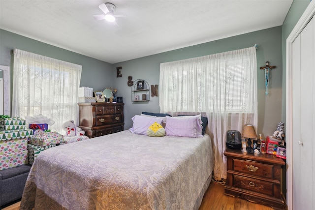 bedroom featuring ceiling fan, light wood-type flooring, and a closet