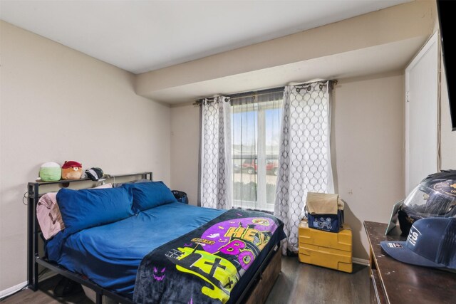 bedroom with dark hardwood / wood-style flooring