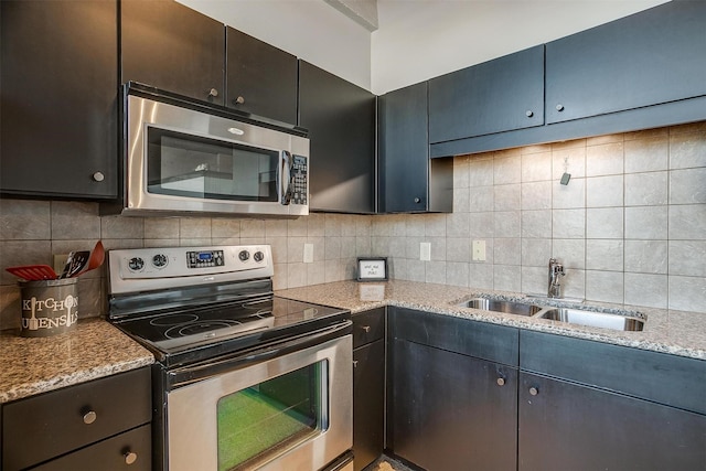 kitchen featuring light stone counters, sink, decorative backsplash, and appliances with stainless steel finishes