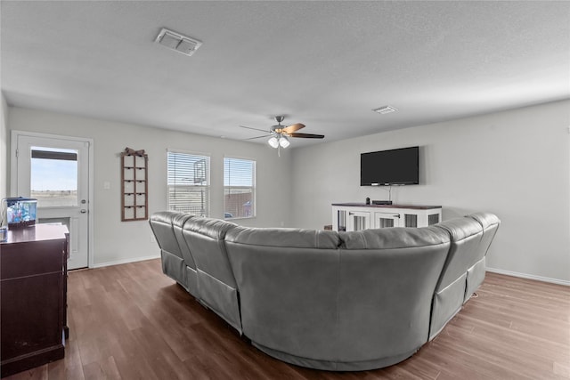 living room featuring wood-type flooring, plenty of natural light, and ceiling fan