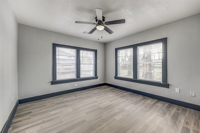 empty room featuring ceiling fan, light hardwood / wood-style floors, and a textured ceiling