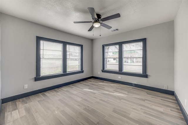 spare room with ceiling fan, a textured ceiling, and light hardwood / wood-style flooring