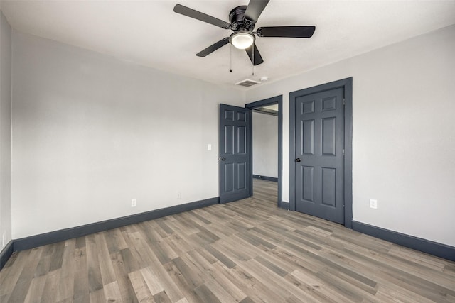 unfurnished bedroom with ceiling fan and wood-type flooring