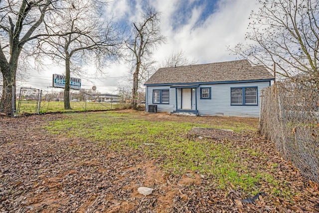 view of front of home with a front yard and central AC