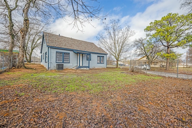 rear view of property featuring cooling unit and a lawn