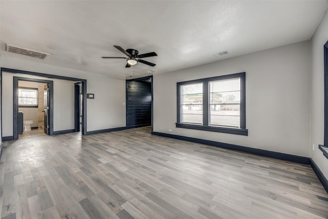 spare room with a textured ceiling, light hardwood / wood-style floors, and ceiling fan