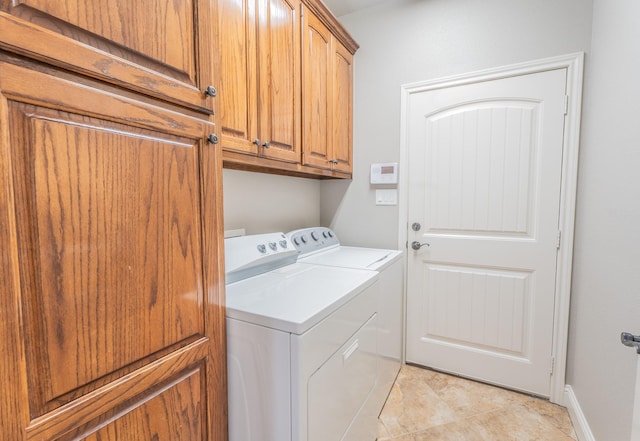 washroom with cabinets, light tile patterned floors, and washer and dryer