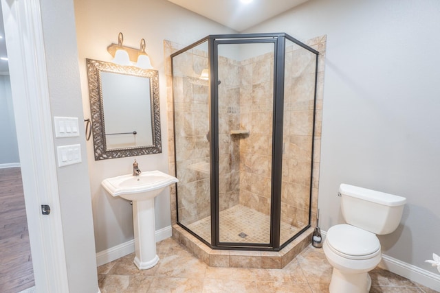 bathroom featuring toilet and a shower with door