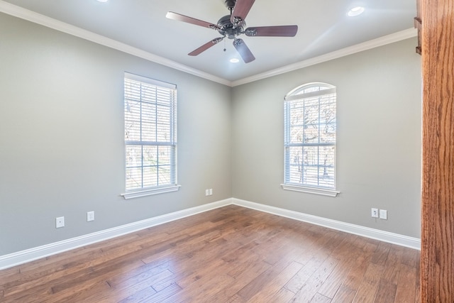 empty room with wood-type flooring, a wealth of natural light, ornamental molding, and ceiling fan