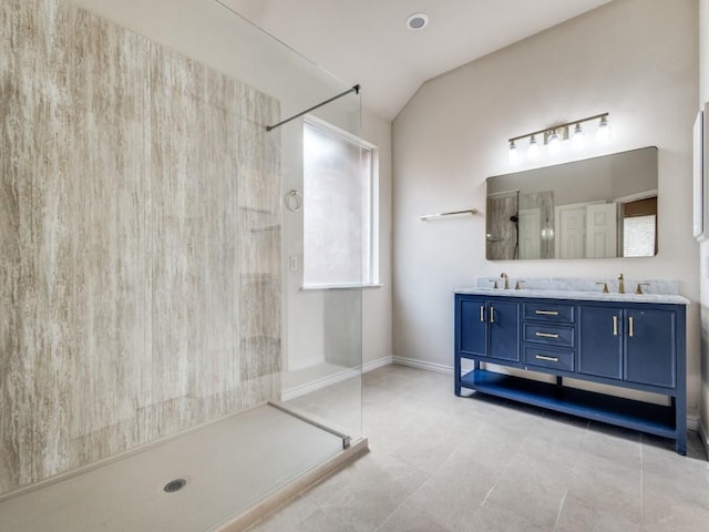 bathroom featuring tile patterned flooring, vanity, a shower, and vaulted ceiling