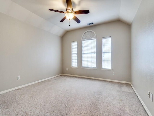 empty room featuring carpet flooring, ceiling fan, and vaulted ceiling