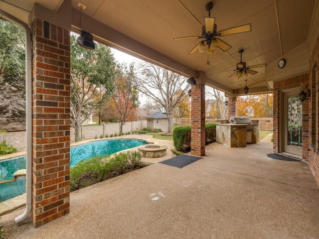 view of patio / terrace featuring ceiling fan, an outdoor kitchen, an outdoor fire pit, grilling area, and a fenced in pool