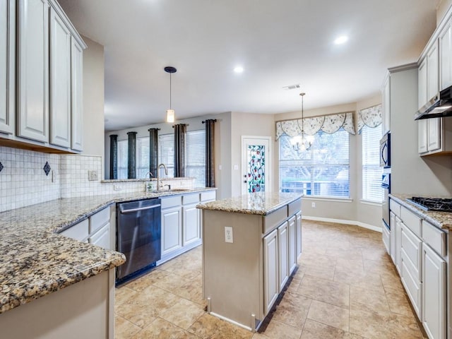 kitchen featuring pendant lighting, a kitchen island, light stone counters, and stainless steel appliances