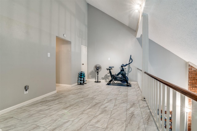 workout room featuring high vaulted ceiling