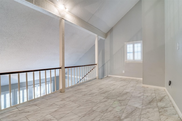 empty room featuring vaulted ceiling with beams