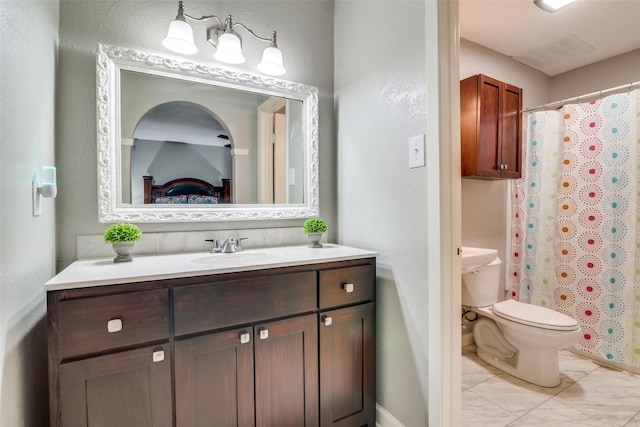 bathroom with tile patterned flooring, vanity, and toilet