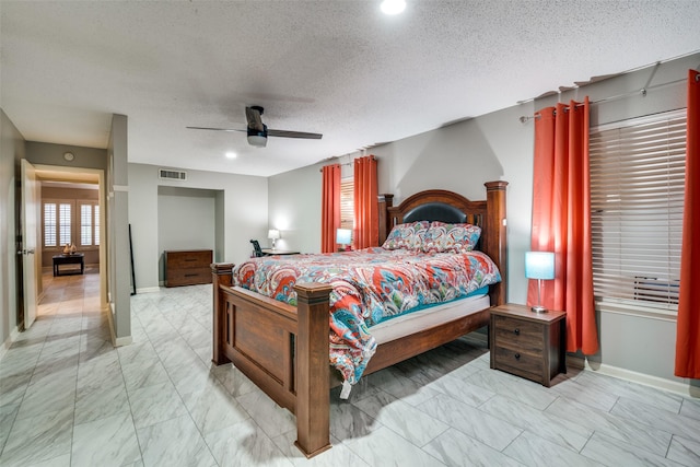 bedroom with ceiling fan and a textured ceiling