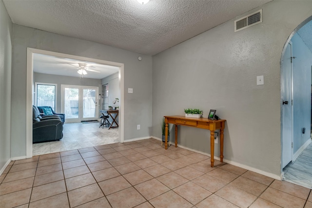 entrance foyer featuring ceiling fan, light tile patterned floors, and a textured ceiling