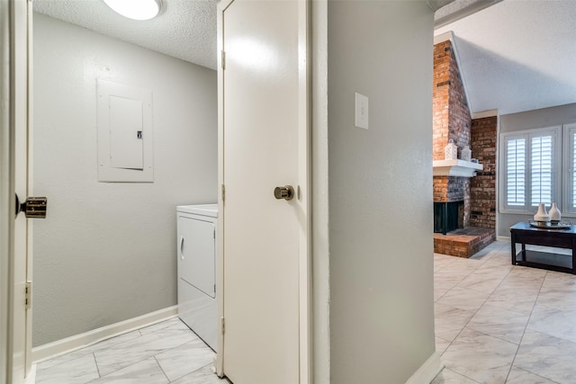 bathroom with a textured ceiling, electric panel, a brick fireplace, and washer / clothes dryer