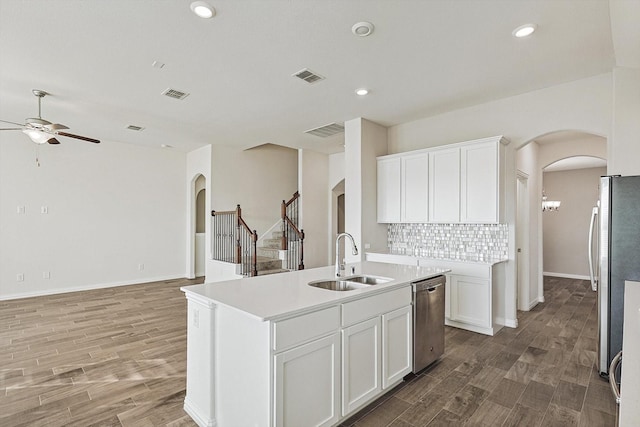 kitchen featuring a kitchen island with sink, sink, tasteful backsplash, white cabinetry, and stainless steel appliances