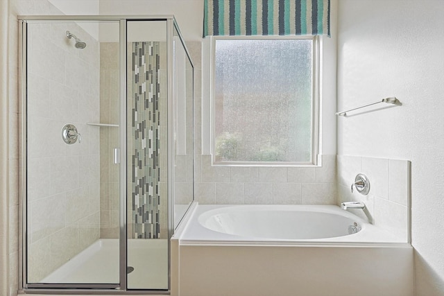 bathroom featuring separate shower and tub and plenty of natural light