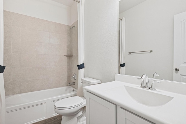 full bathroom with vanity, tiled shower / bath combo, hardwood / wood-style flooring, and toilet