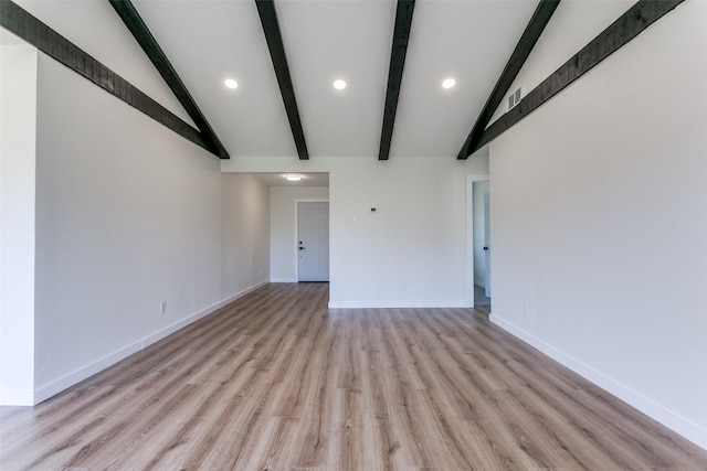 unfurnished living room featuring vaulted ceiling with beams and light wood-type flooring