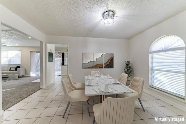 1629 Shreveport Trl, Plano, TX 75023 - dining space featuring a textured ceiling, light carpet, light tile patterned flooring, and baseboards