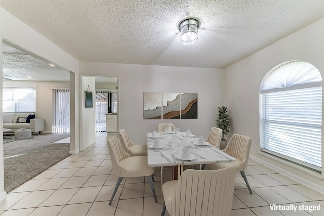 tiled dining room with a textured ceiling