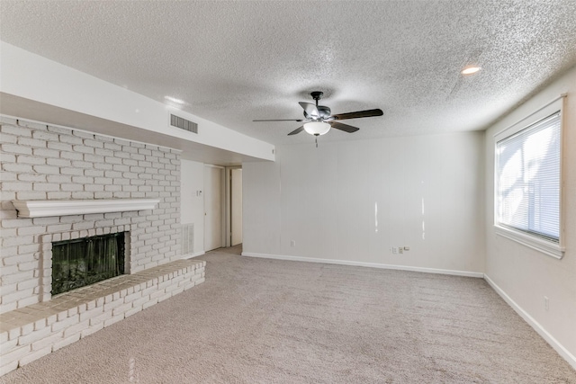 unfurnished living room featuring a fireplace, carpet, and a textured ceiling