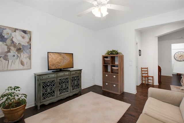 living room featuring ceiling fan and dark hardwood / wood-style flooring