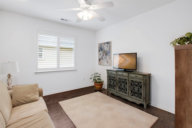 living room featuring ceiling fan and dark hardwood / wood-style floors