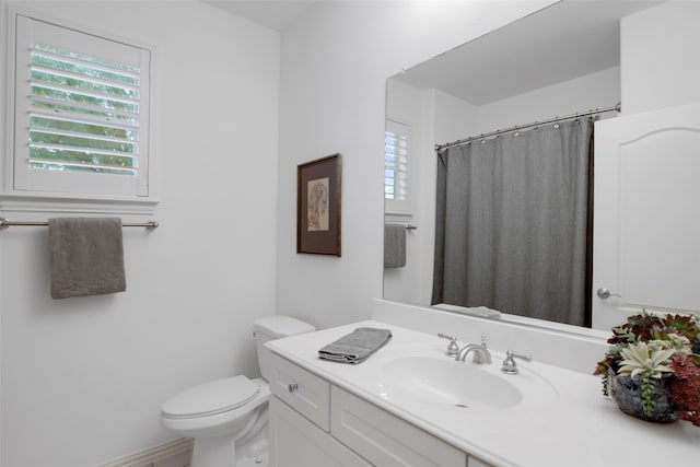 bathroom with a shower with shower curtain, vanity, and toilet