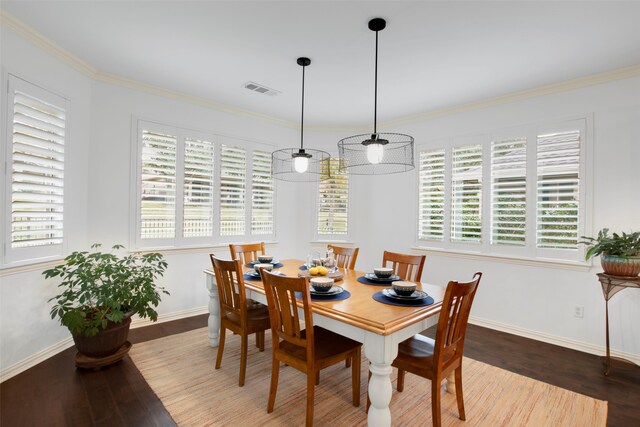 dining room with hardwood / wood-style floors, ornamental molding, and a healthy amount of sunlight